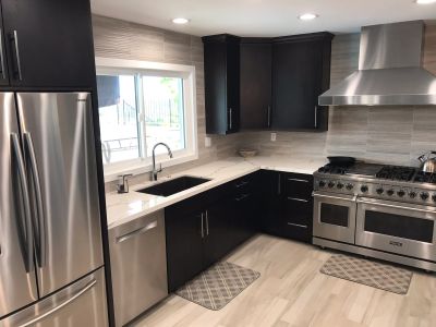 Modern kitchen with stainless steel appliances and dark cabinets.