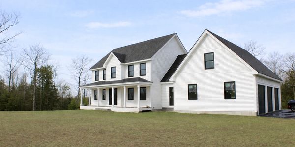 White two-story house with a large front porch and attached garage.
