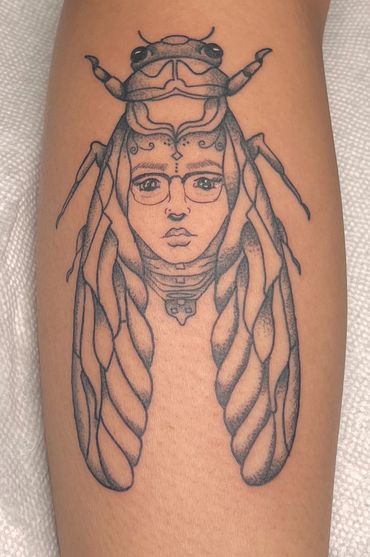 Custom tattoo of a cicada with a lady face.