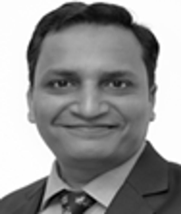 Black and white portrait of a smiling man in a suit.