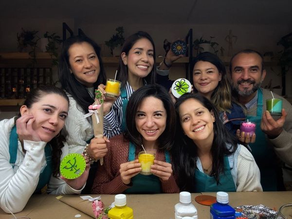 Grupo de personas sonriendo después de hacer un taller de velas y pintura