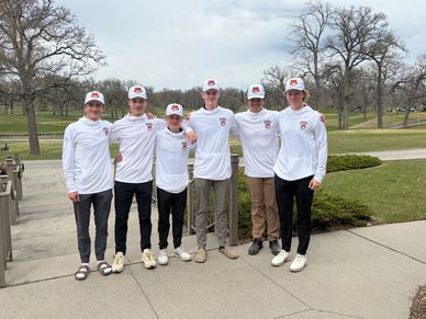 A group of six young men in matching white shirts and caps posing outdoors.