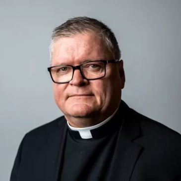 Fr. Darin Connall with the Cathedral of Our Lady of Lourdes in Spokane Washington