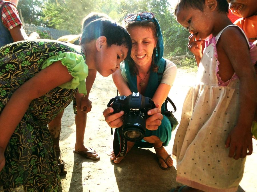 Flóra Zsemlye, photographer and videographer, shows her camera to some curious children.