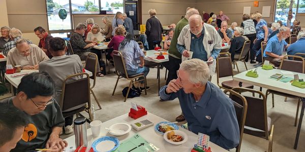 Seniors engaging in a lively bingo game in a community hall.