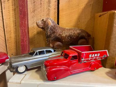 Vintage toy vehicles and a carved wooden dog.