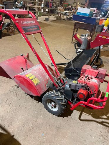 Red Troy-Bilt tiller in a workshop.