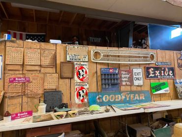 Vintage and antique sign collection on a wooden wall.