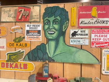 Green elf mural surrounded by vintage signs.