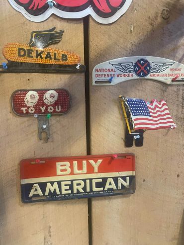 Vintage patriotic and brand signs on a wooden wall.