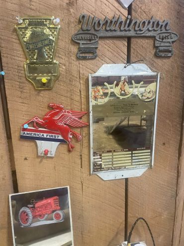 Vintage signs and plaques on a wooden wall.