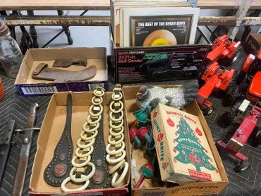 Box of vintage Christmas lights and tools on a workbench.