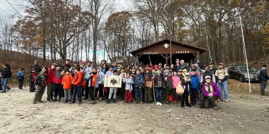 A large group of scouts and leaders gathered outside Sperling Center in autumn.