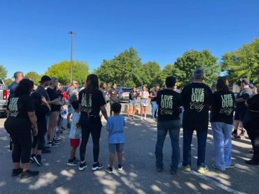 People gathered outdoors, some wearing matching shirts.