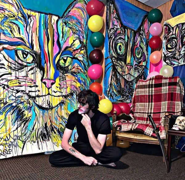 Artist Russell Frantom sits with his Cat Artwork 