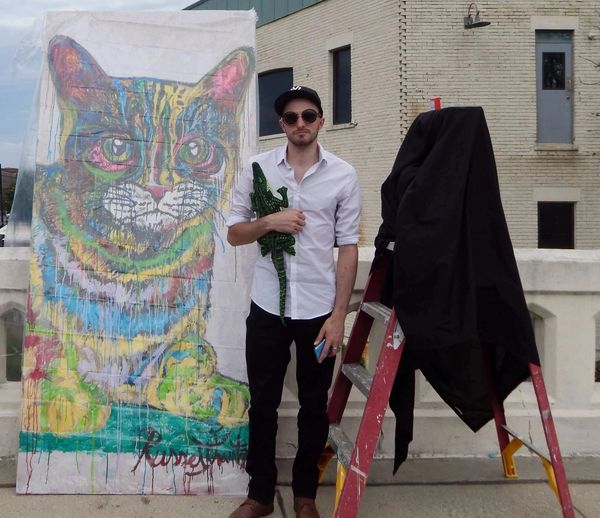 Artist Russell Frantom stands with cat painting 2019 south bend indiana 