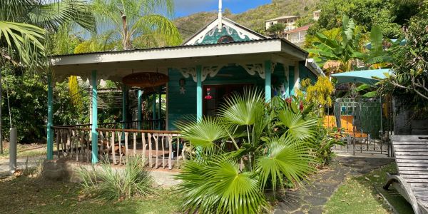 Small tropical house with lush greenery.