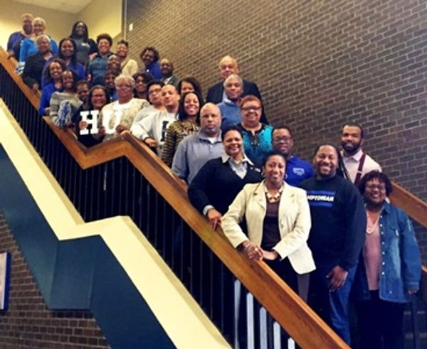 A diverse group of people standing on a staircase posing for a photo.