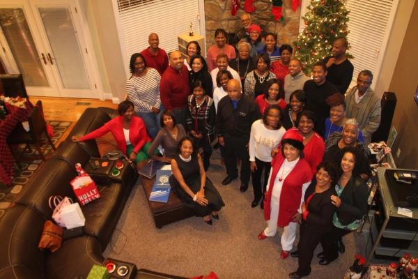 A large group of people gathered indoors for a holiday celebration.