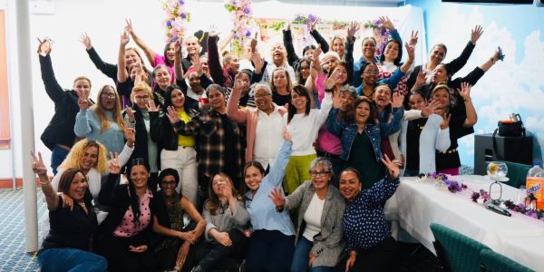 Gran grupo de mujeres celebrando juntas con alegría.