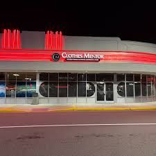 Clothes Mentor store front at night with red neon lights.