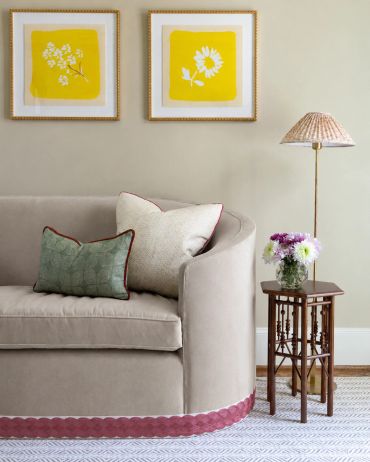 Cozy living area with neutral sofa and bright yellow floral artwork.