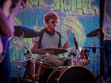 drummer wearing sunglasses playing the drums live