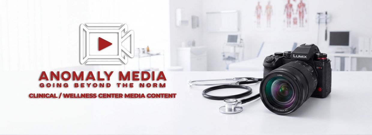Camera and stethoscope on a desk with Anomaly Media logo and tagline in a clinical setting.