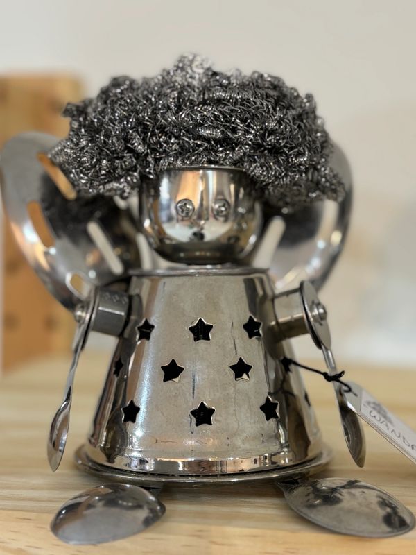Stainless steel objects placed together with rivets to create a whimsical girl.