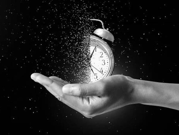 A picture of a human hand holding a clock that is slowly disintegrating. 