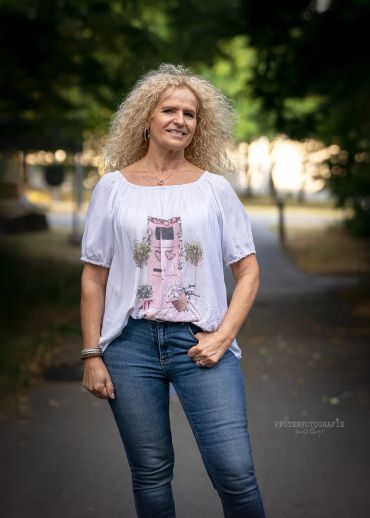 Frau mit lockigen blonden Haaren im Freien.