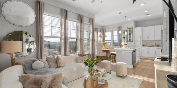 Bright and cozy open living room and kitchen with neutral tones and natural light.