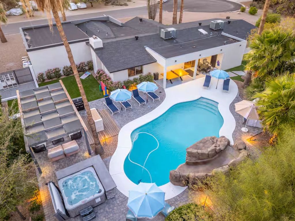 Modern house with pool, hot tub, and outdoor seating.