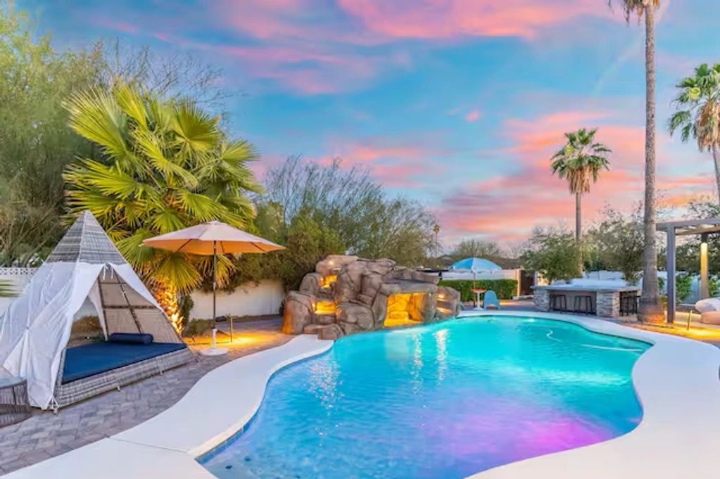 Beautiful backyard pool with vibrant sunset sky.