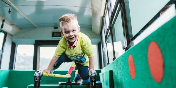 Child playing on a gymnastics bus beam.