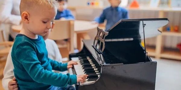 A young child playing a mini piano indoors.