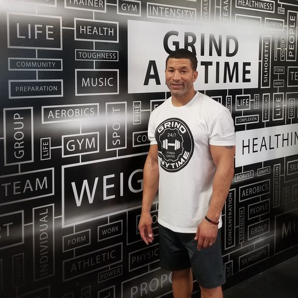 Sean Bannister standing next to Grind Anytime Motivation Wall.