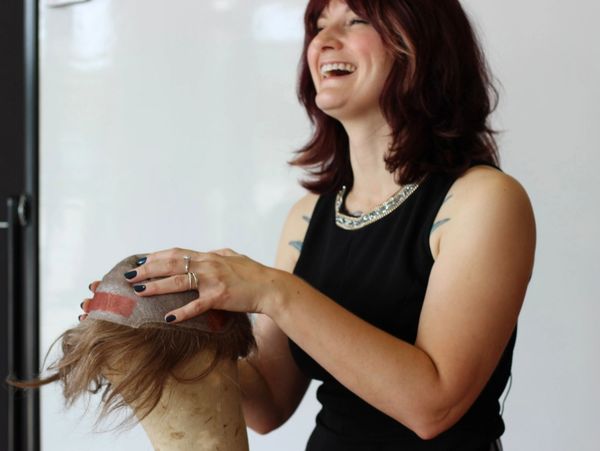 A person holding a hair replacement unit