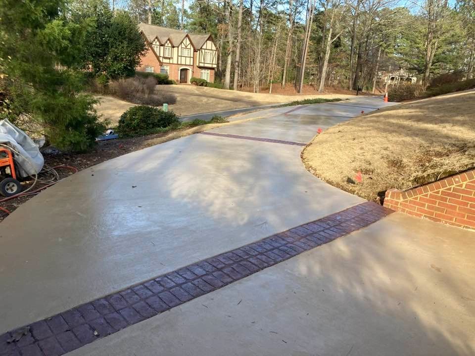 A decorative driveway with stamped and colored concrete between normal concrete sections.