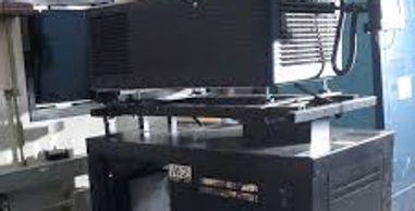 Large black electronic equipment with a screen and keyboard in a room.