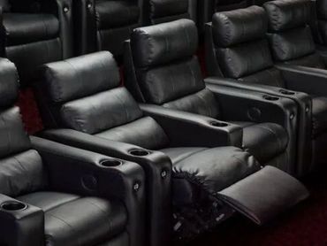 Row of black reclining leather theater seats.