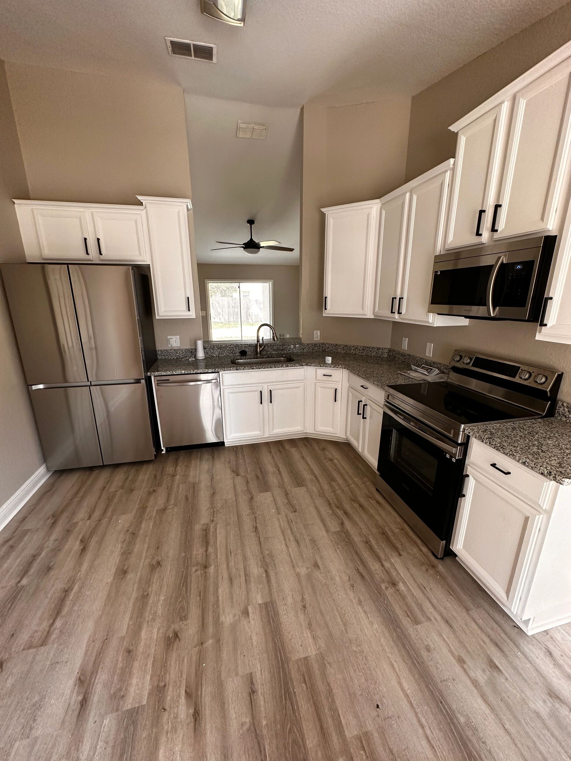 A room half-painted blue with a ladder and paint supplies.