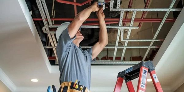 Technician installing water pipes for fire protection sprinkler system