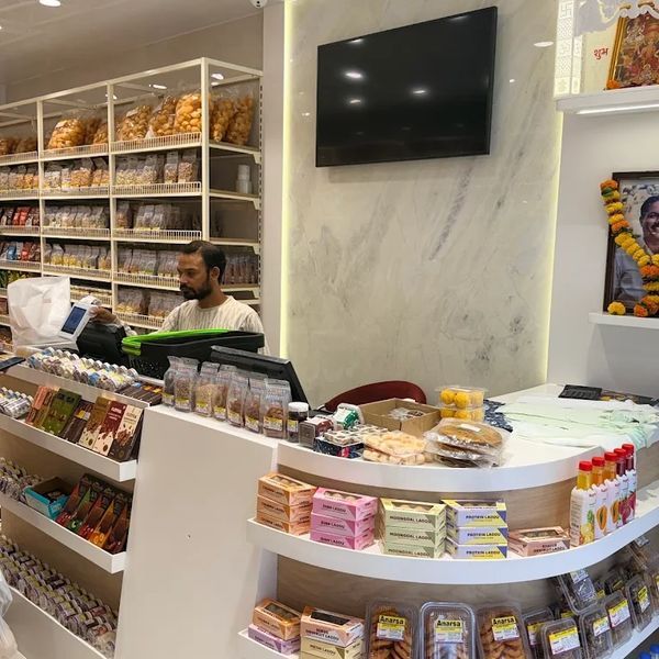 Man working behind the counter in a well-stocked snack shop.
