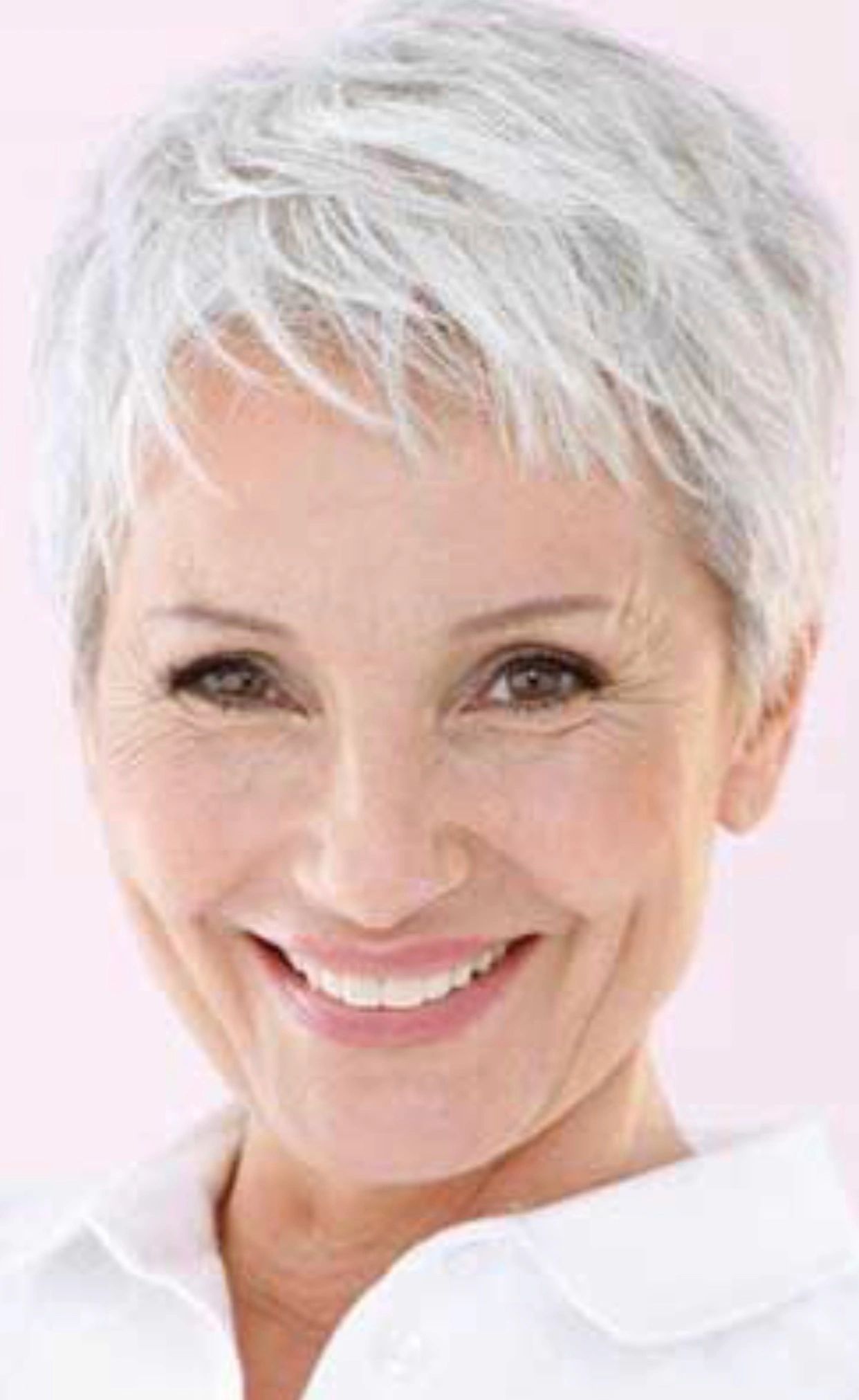 Smiling middle-aged woman with short gray hair and bright eyes.