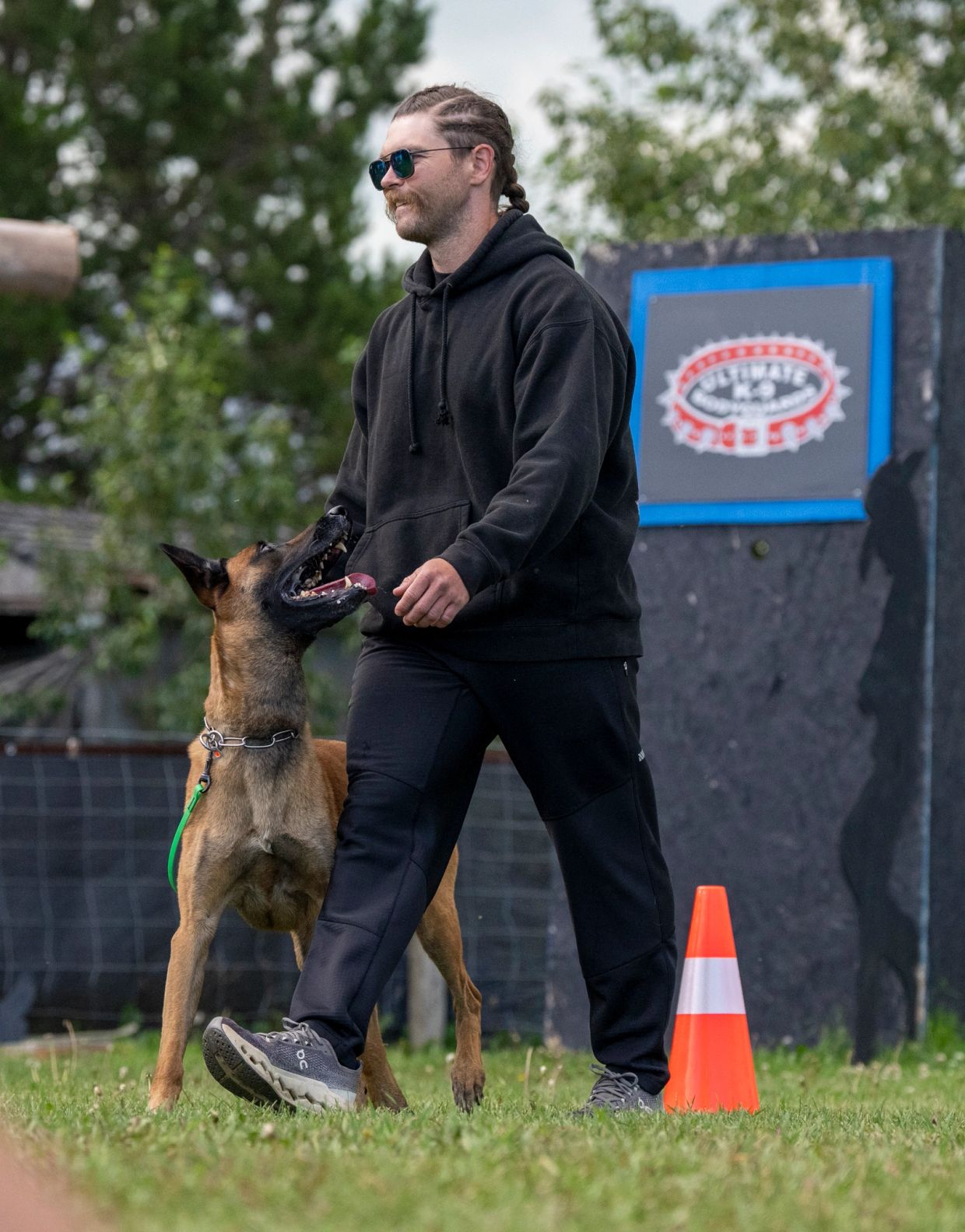 Man walking with attentive dog outdoors.