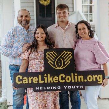 Family holding CareLikeColin.org sign.
