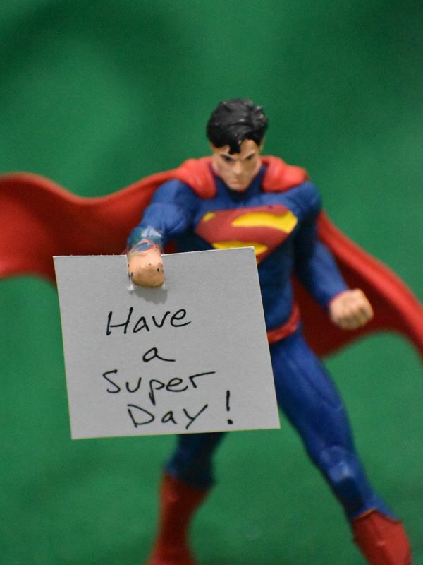 Picture of SuperMan figure holding a sign saying "Have a Super Day."