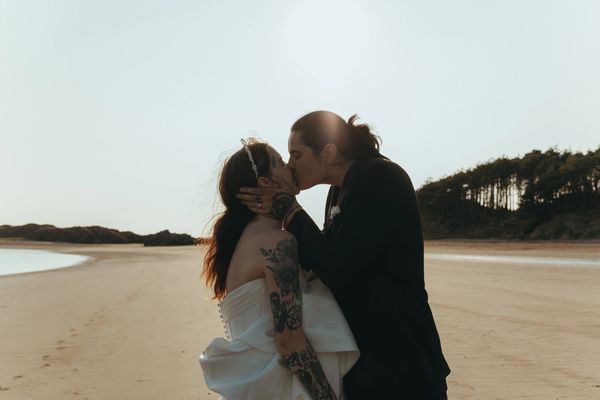 Couple kiss during their elopement wedding ceremony on Anglesey beach - LGBTQ+ lesbian wedding