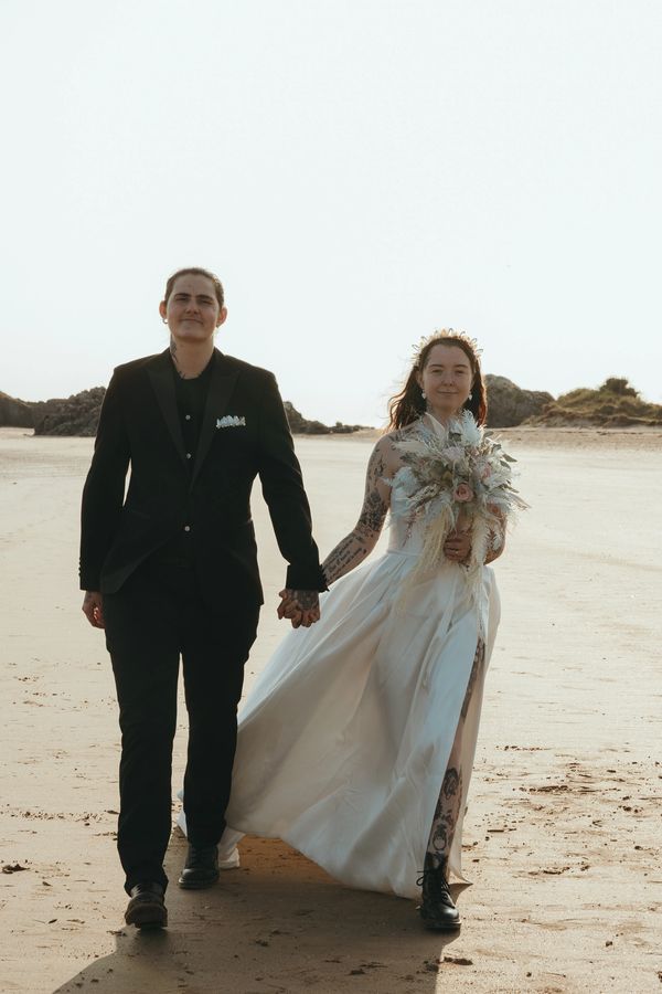 Anglesey beach elopement ceremony -  lesbian couple holding hands